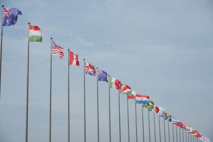 Fileira de bandeiras internacionais hasteadas, simbolizando relações diplomáticas e alianças entre países