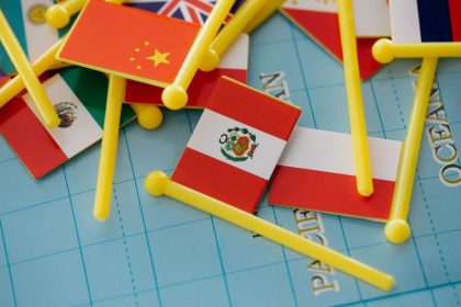 Miniaturas de bandeiras dispostas sobre um mapa-múndi, representando relações internacionais e diversidade global.