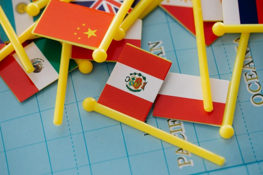 Miniaturas de bandeiras dispostas sobre um mapa-múndi, representando relações internacionais e diversidade global.